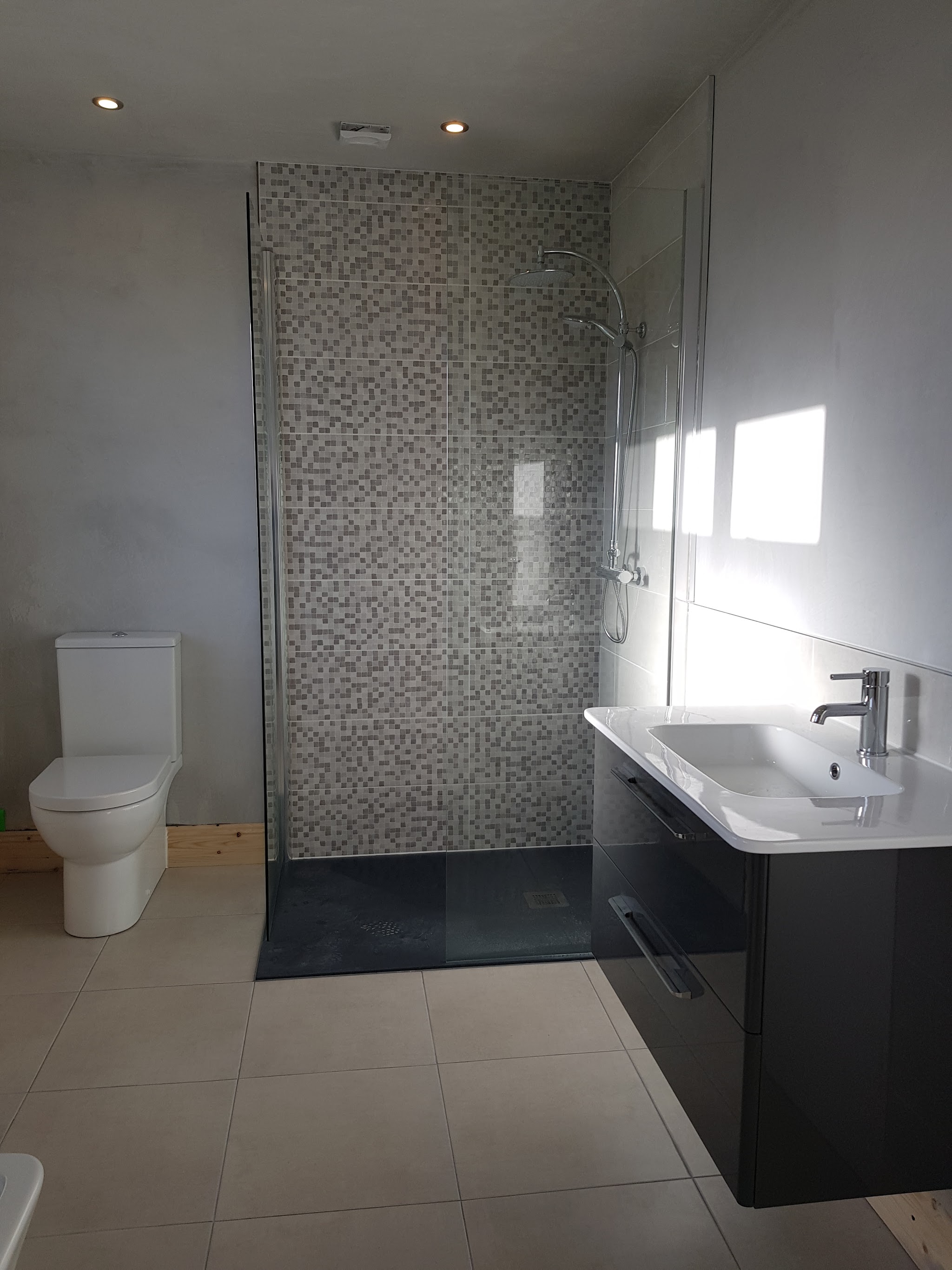 Walk-in shower with a mosaic feature wall and a wall-hung black vanity unit