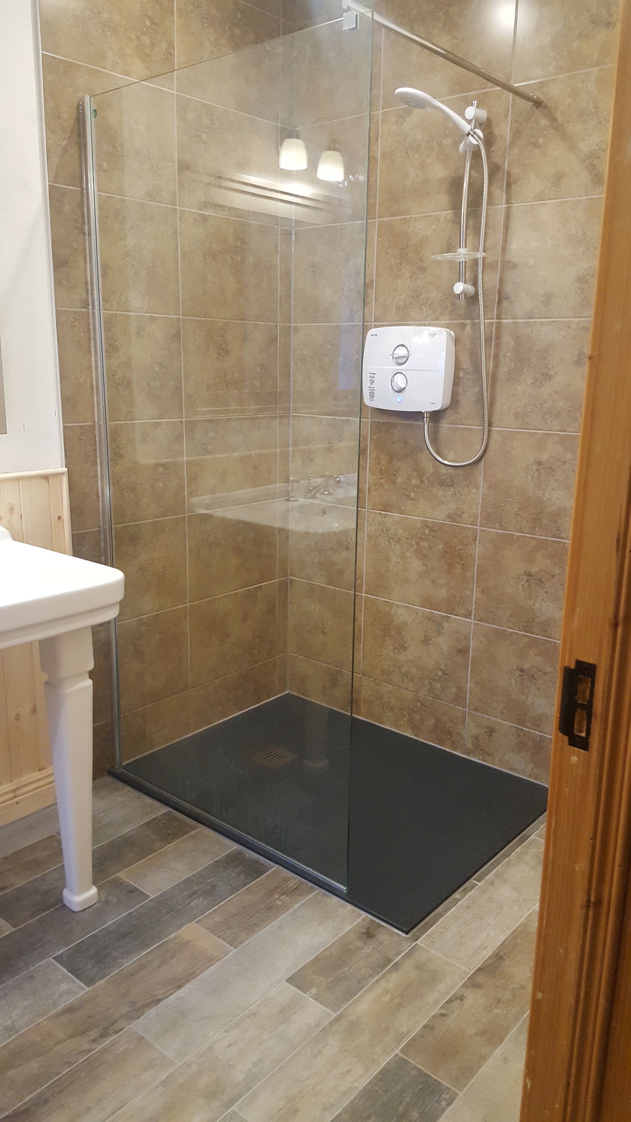 Glass shower enclosure with an electric shower and a slate-grey tray