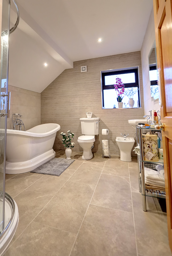 Attic bathroom with a freestanding slipper bath under a sloped ceiling